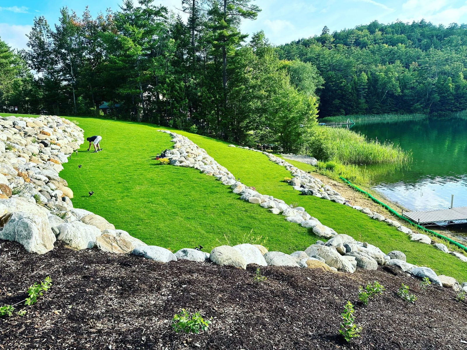 Fresh sod and boulder shoreline edge on a lakefront property